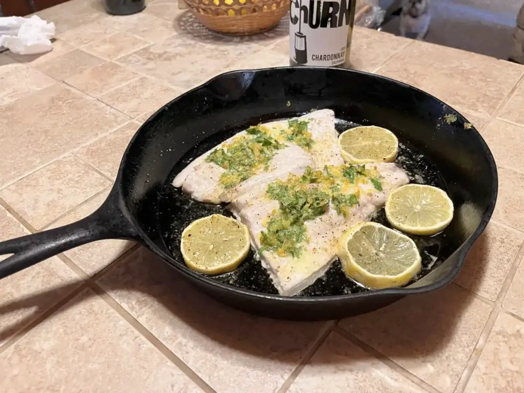 Skillet Baked Whitefish Recipe served in a cast iron skillet with lemon slices