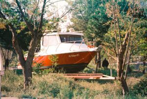 a boat on a trailer standing on a grass field