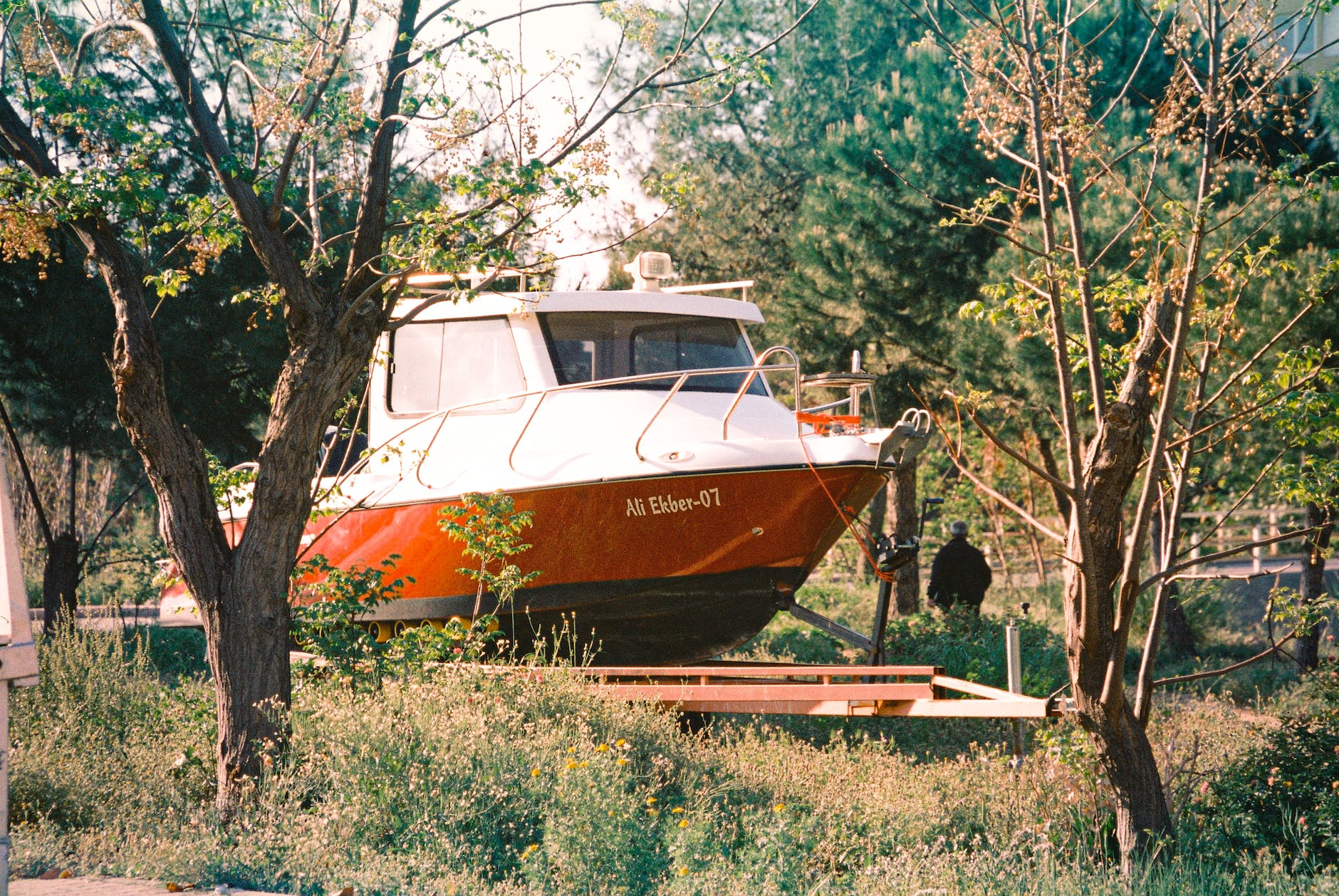 a boat on a trailer standing on a grass field
