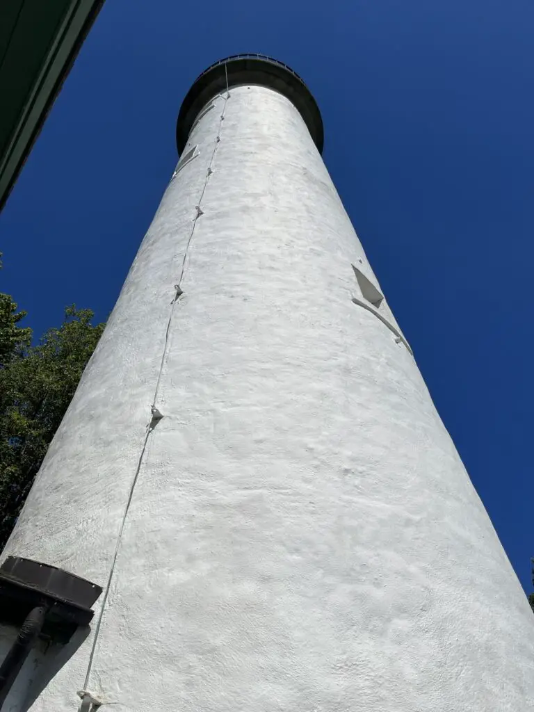 a white lighthouse with a black top