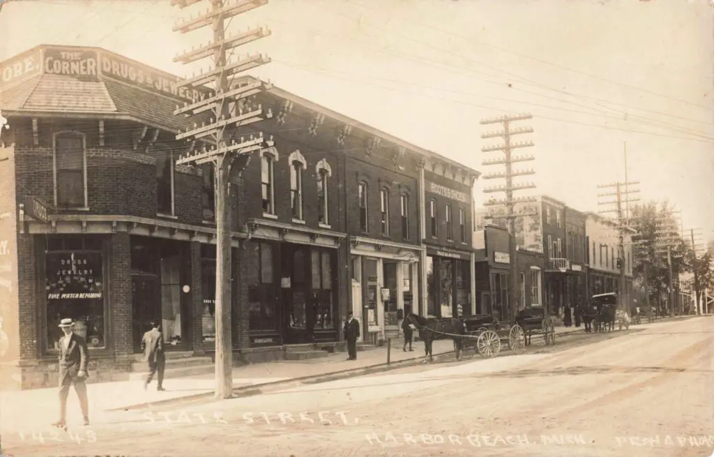 a black and white photo of a street with buildings and a horse drawn carriage