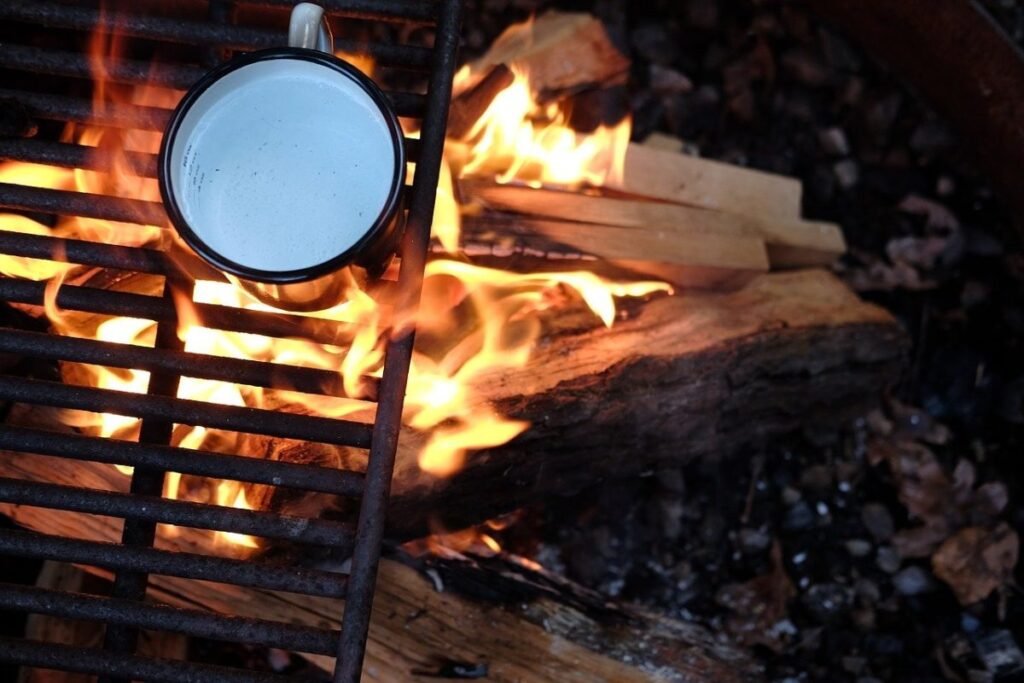 Coffee cup over campfire flames