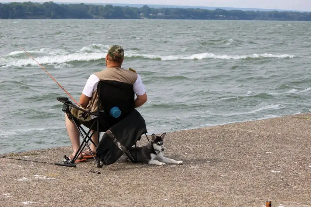 Man Fishing With Dog