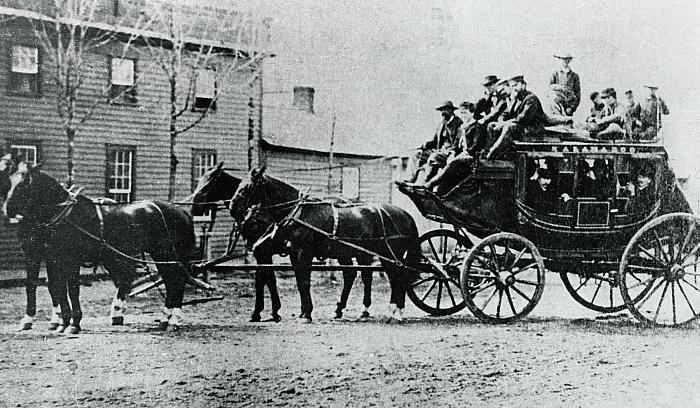 Historic stagecoach with passengers and horses