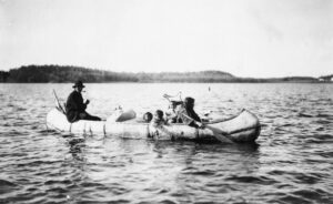 Five Ojibwa Indians: man, woman, and three children in canoe.