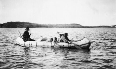 Five Ojibwa Indians: man, woman, and three children in canoe.