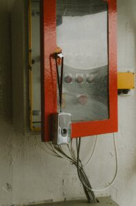 old fashioned camera hanging on an open fuse box