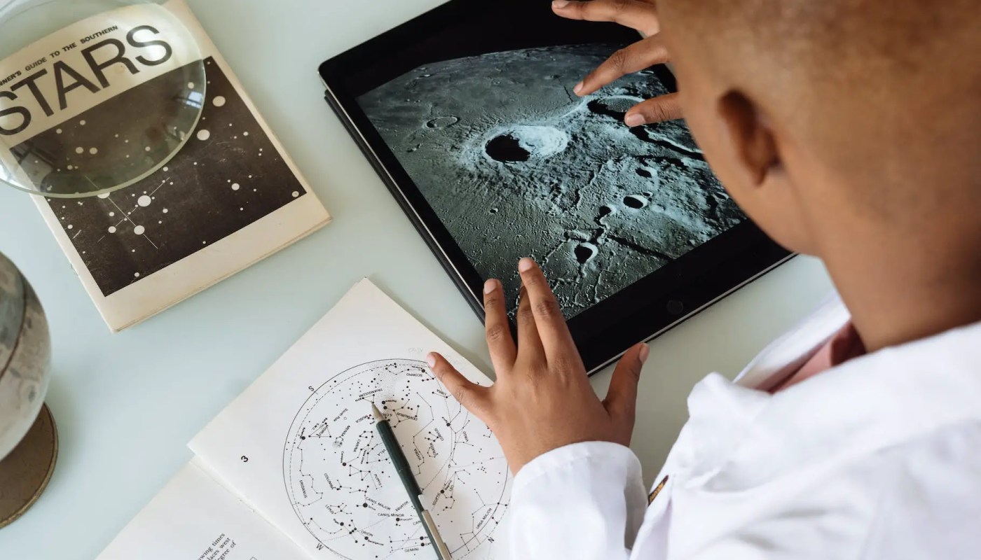 crop african american student studying craters of moon on tablet at observatory - Students engaged in research at a Michigan university lab