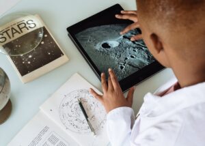 crop african american student studying craters of moon on tablet at observatory - Students engaged in research at a Michigan university lab