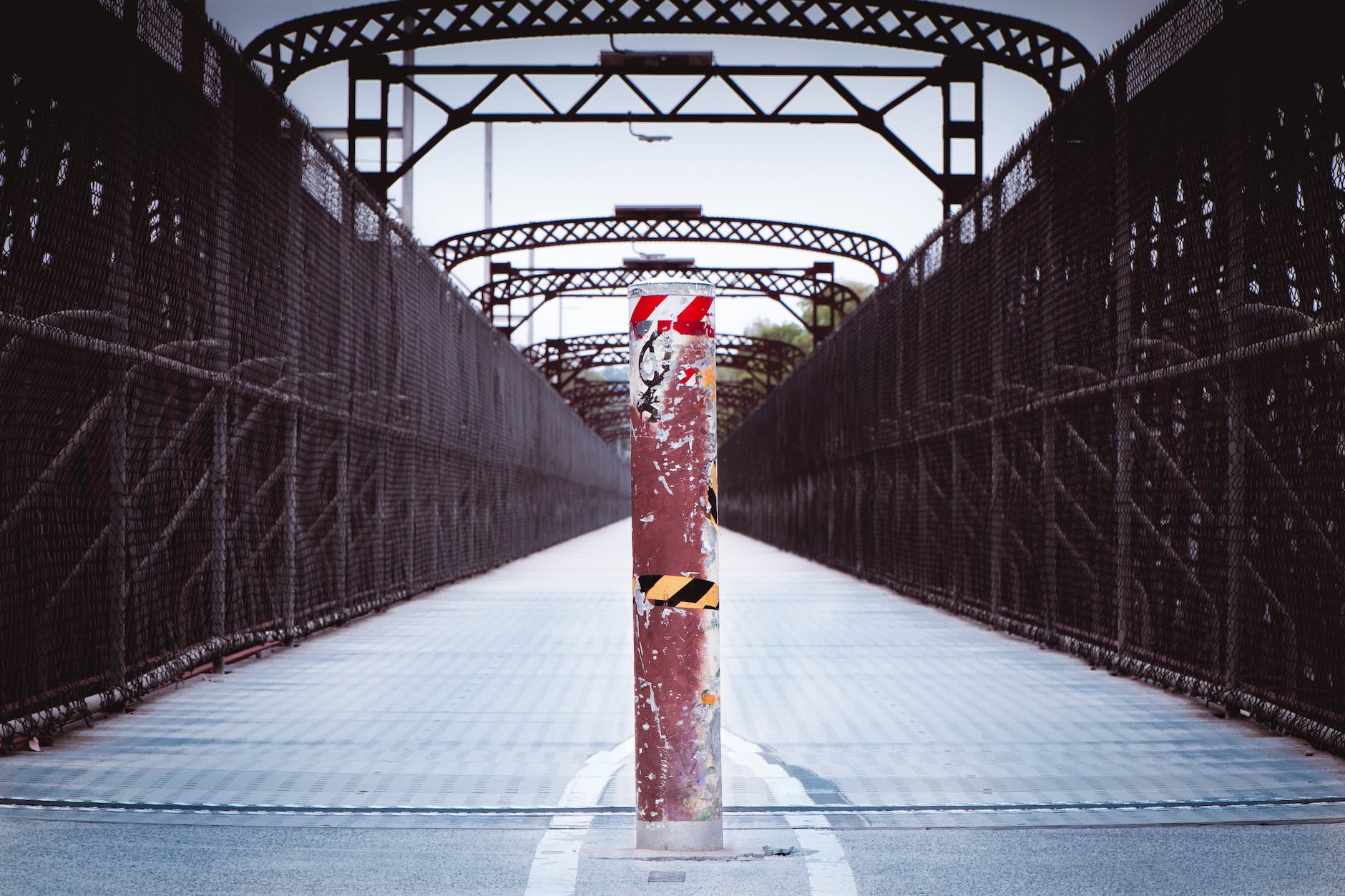 shabby dividing post in middle of pedestrian bridge