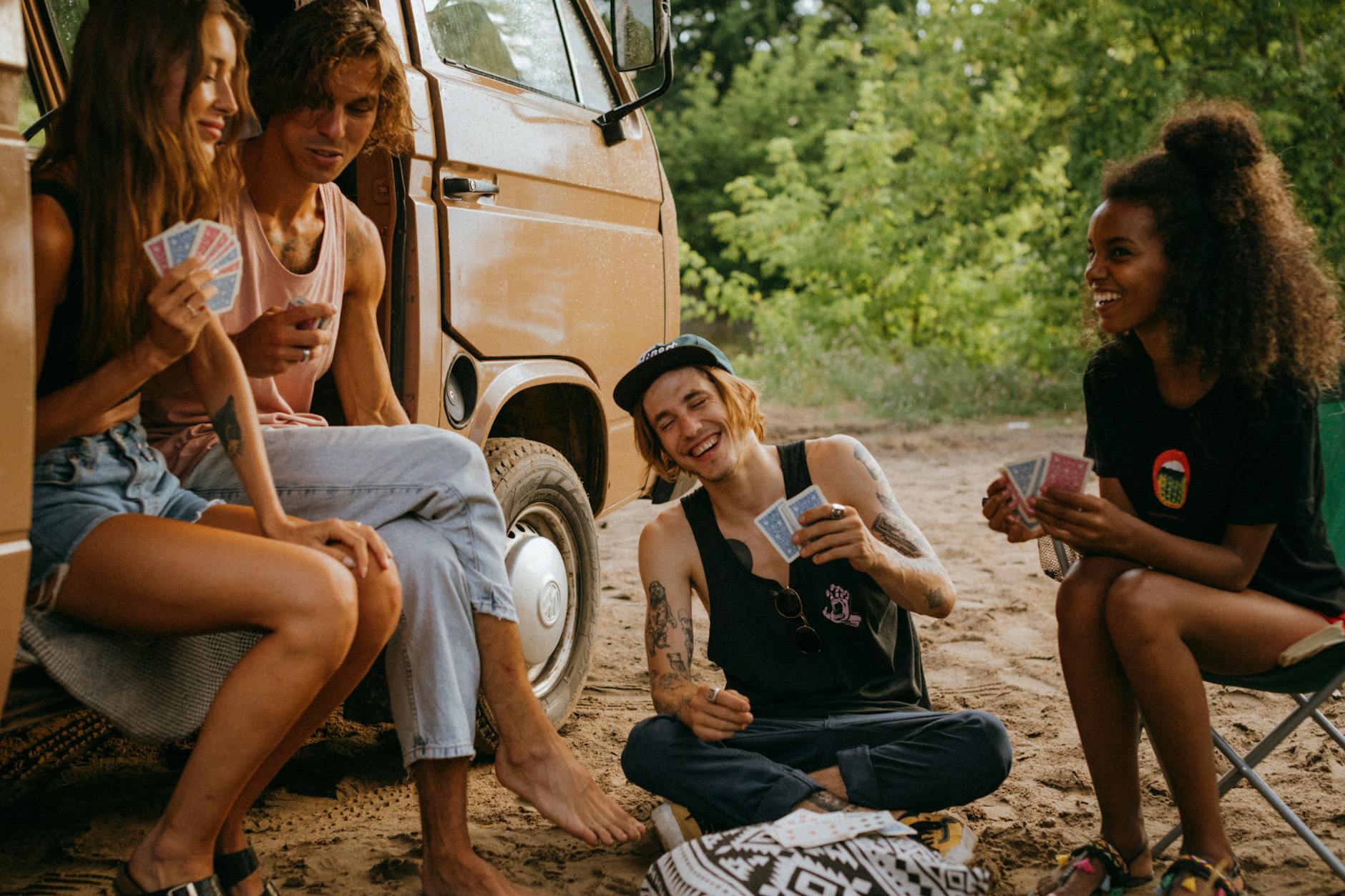 friends playing a card game outside their camper van