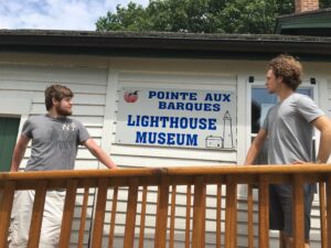 two men standing on a porch of a building