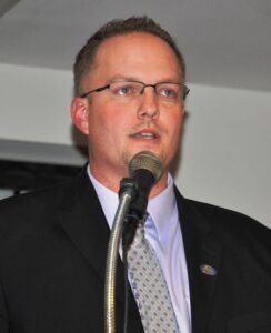 a man in a suit speaking into a microphone