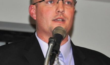 a man in a suit speaking into a microphone