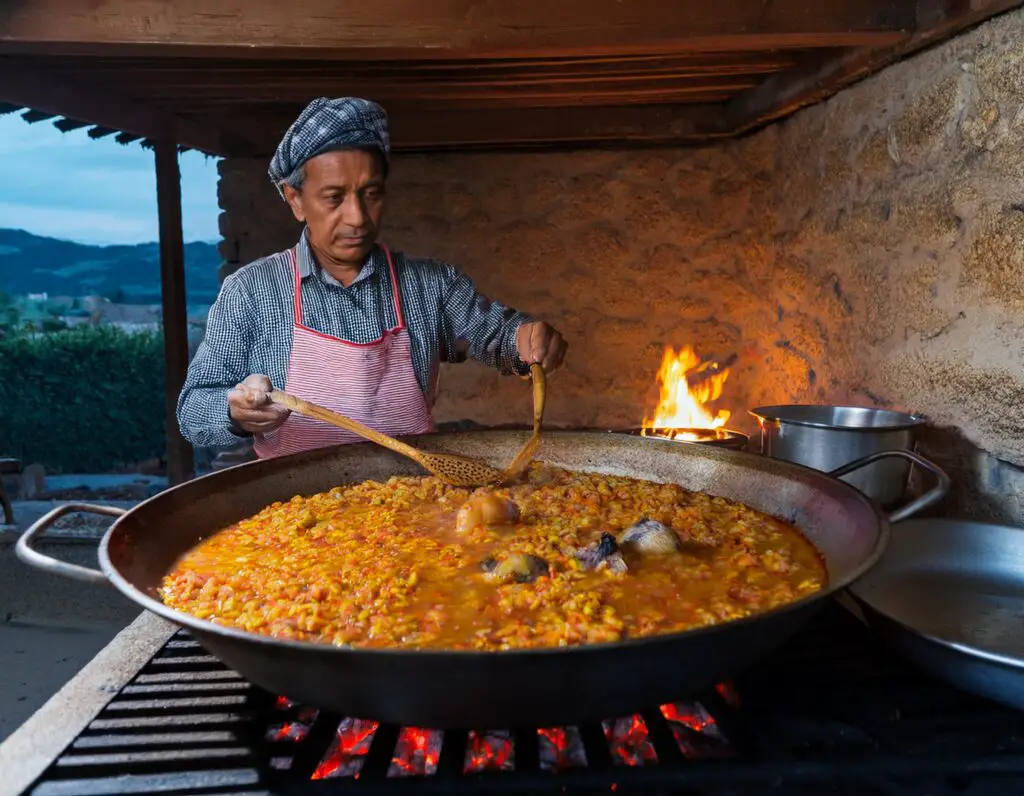 a man cooking food on a large pan