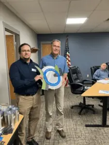 two men holding a circular object in a room