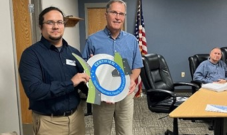 two men holding a circular object in a room