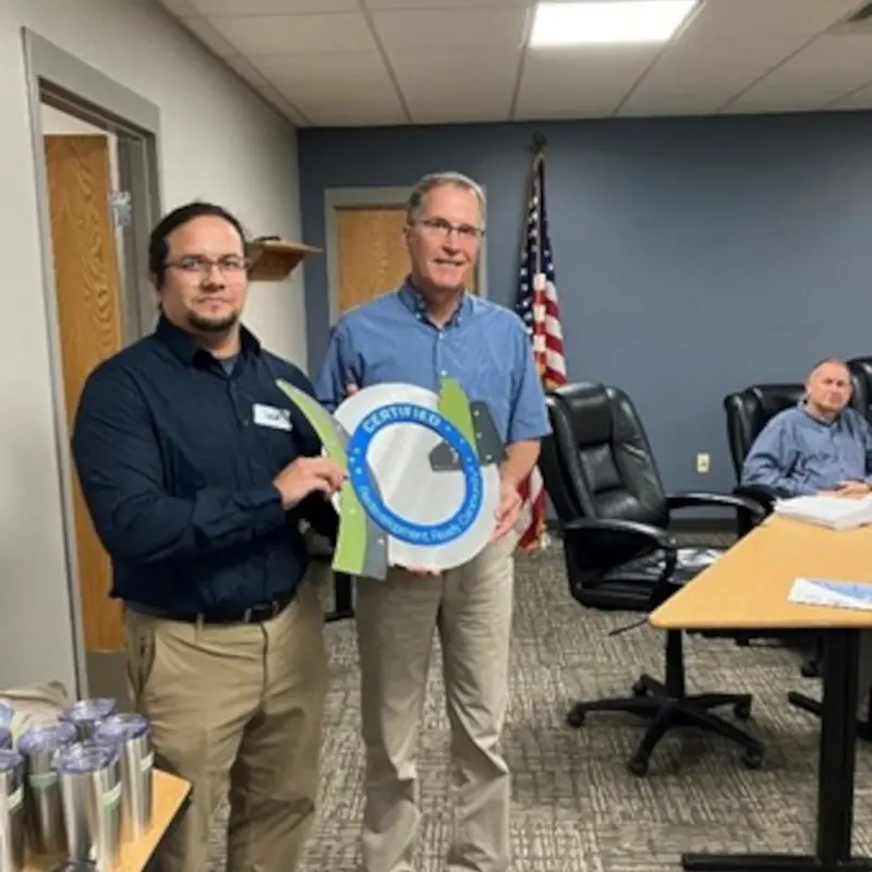 two men holding a circular object in a room