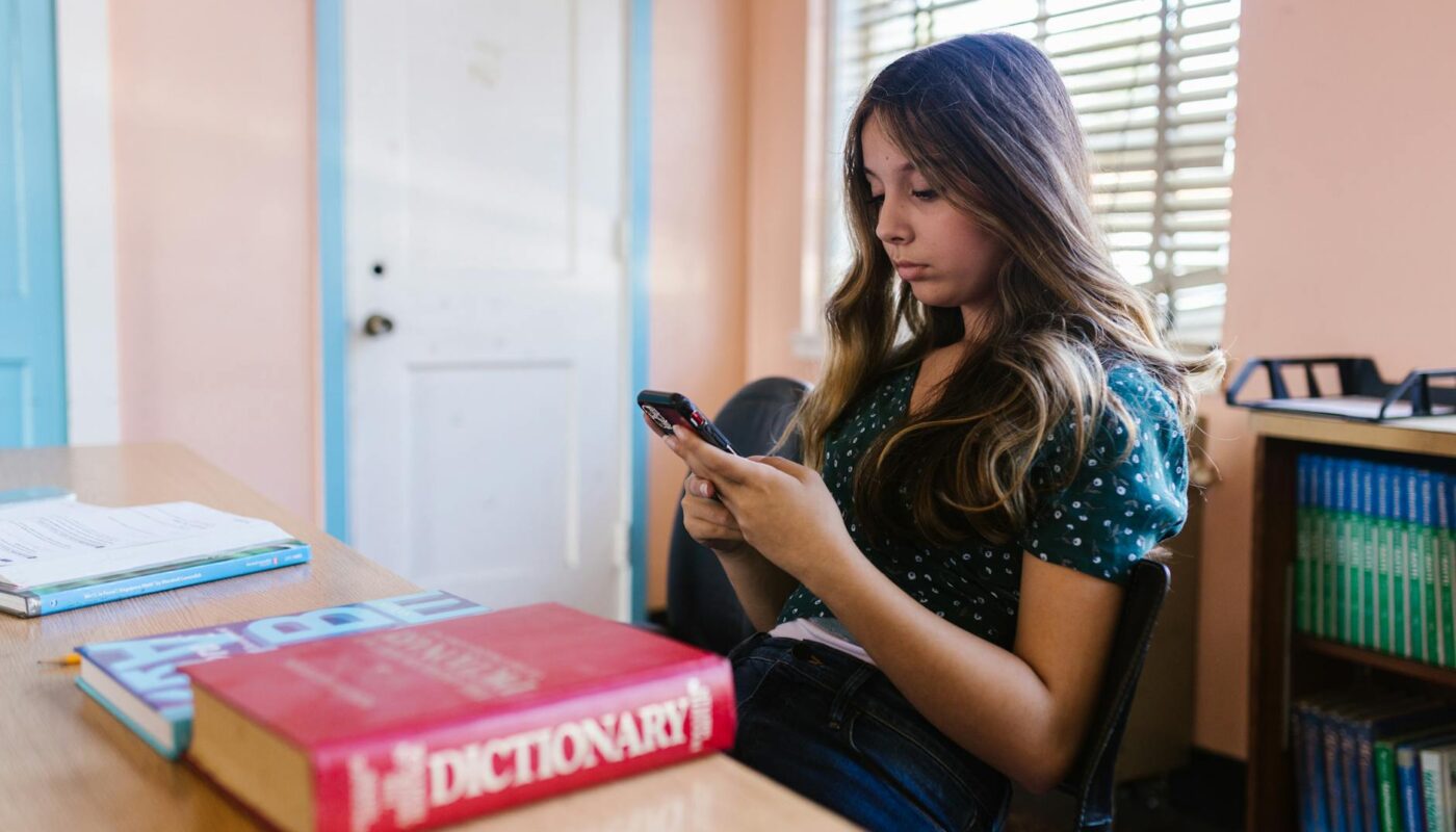 a girl using smartphone in the classroom