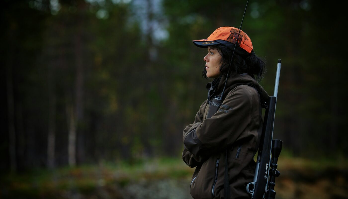 a woman with a gun in the woods