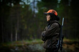 a woman with a gun in the woods