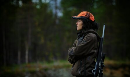 a woman with a gun in the woods