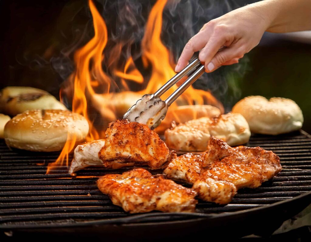 a person cooking meat on a grill