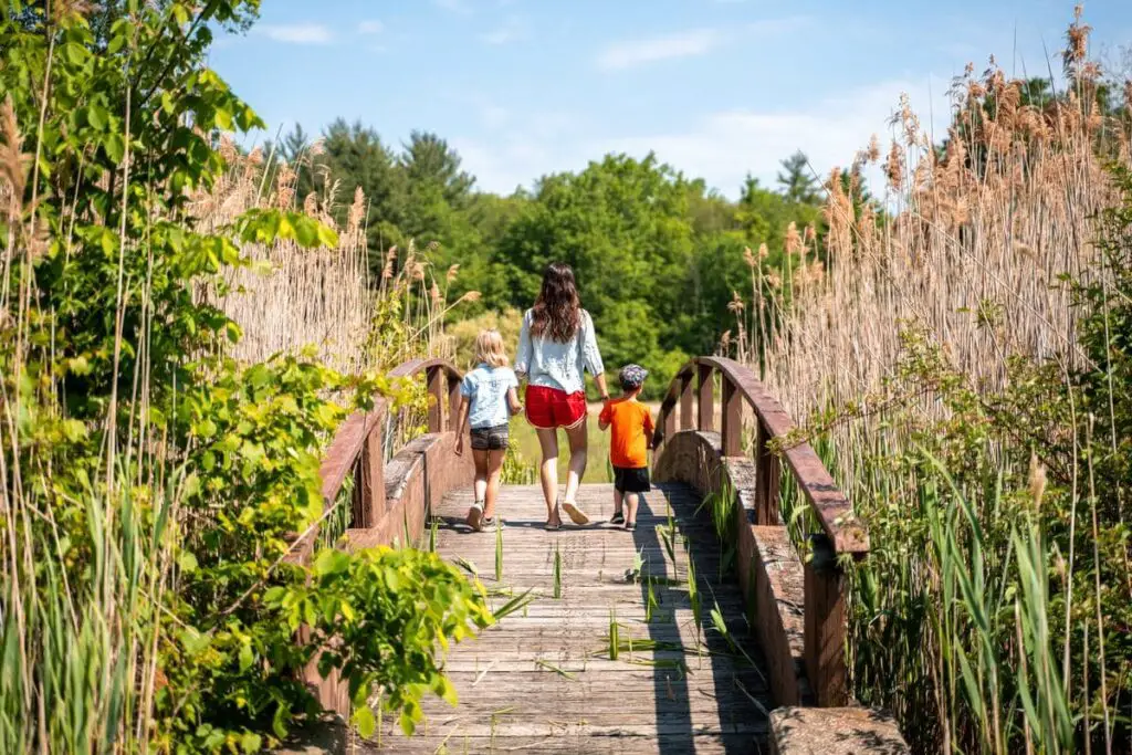 a woman and two children walking on a bridge