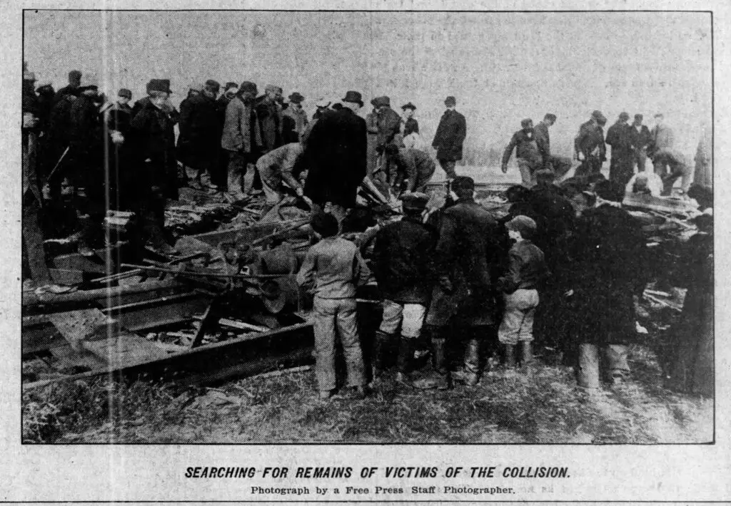a group of people standing around a broken train
