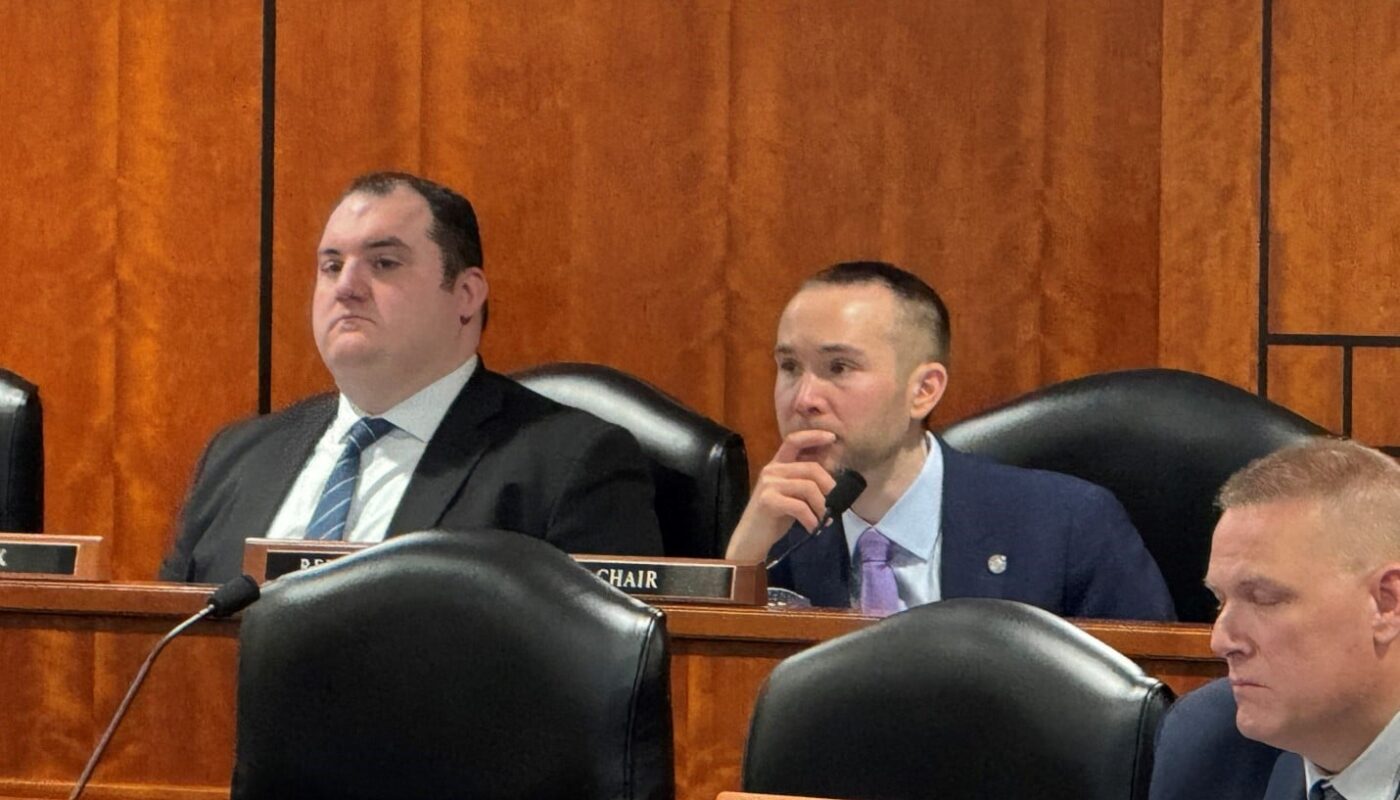 a group of men sitting in a room with microphones