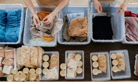 clothing in plastic containers and food in cans on table