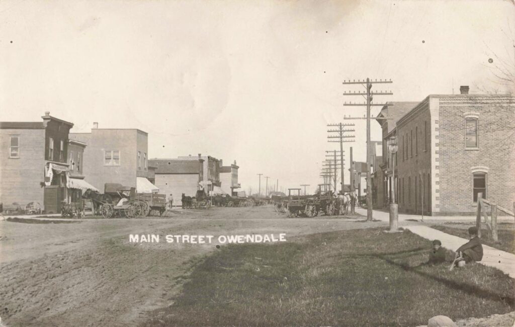 Historic street scene with horse-drawn carriages.