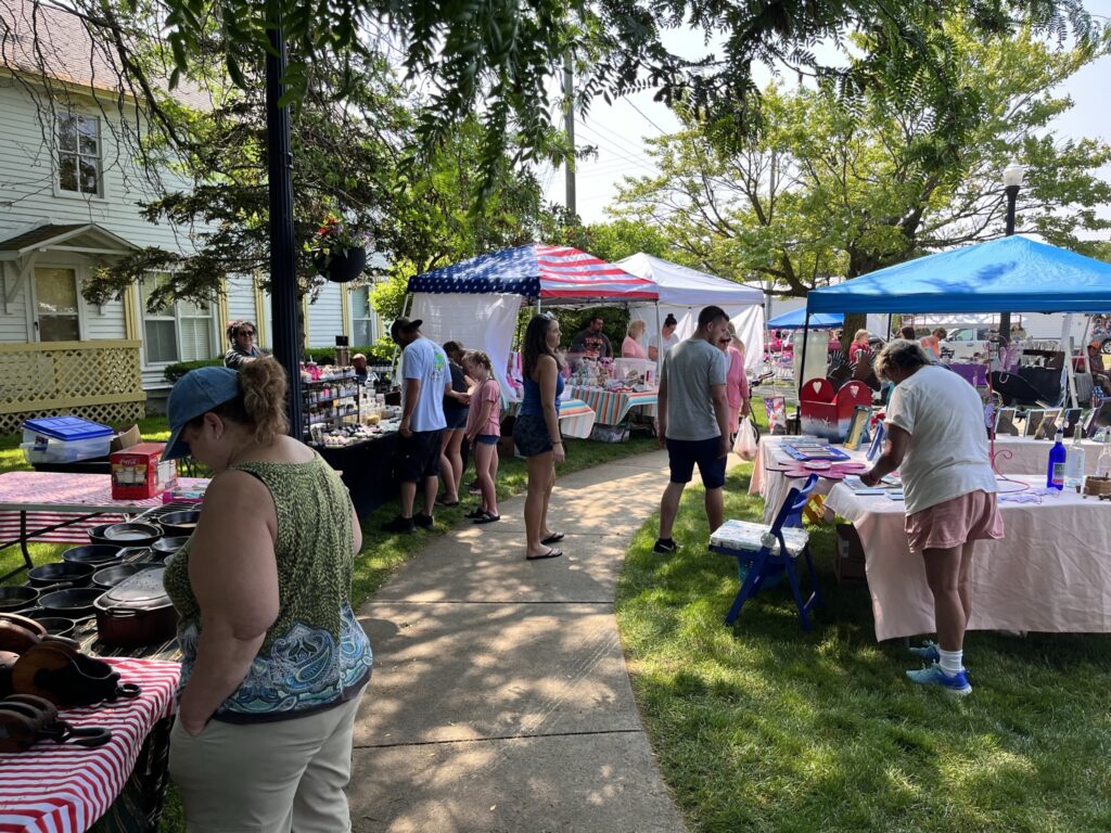 Outdoor market with vendors and shoppers - Caseville Ribstock 2026