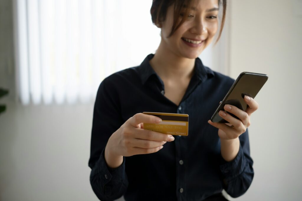 a woman holding a credit card and a phone
