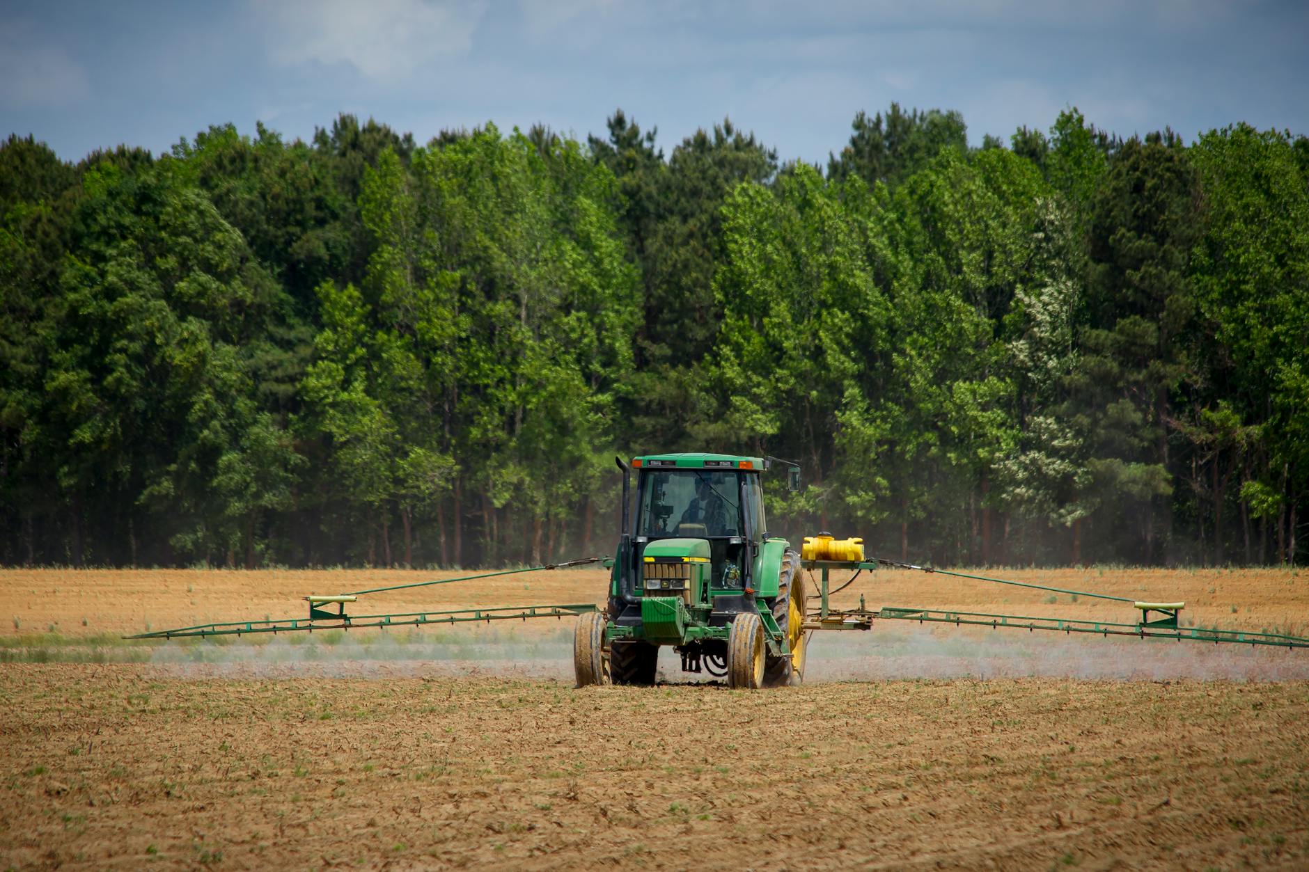 green tractor in field - Neonic Pesticides in Michigan