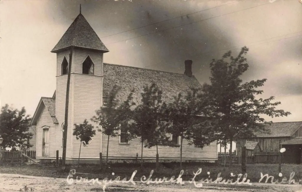 a church with a steeple and trees