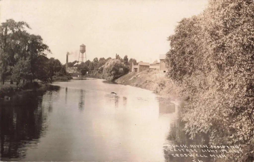 a river with trees and water tower