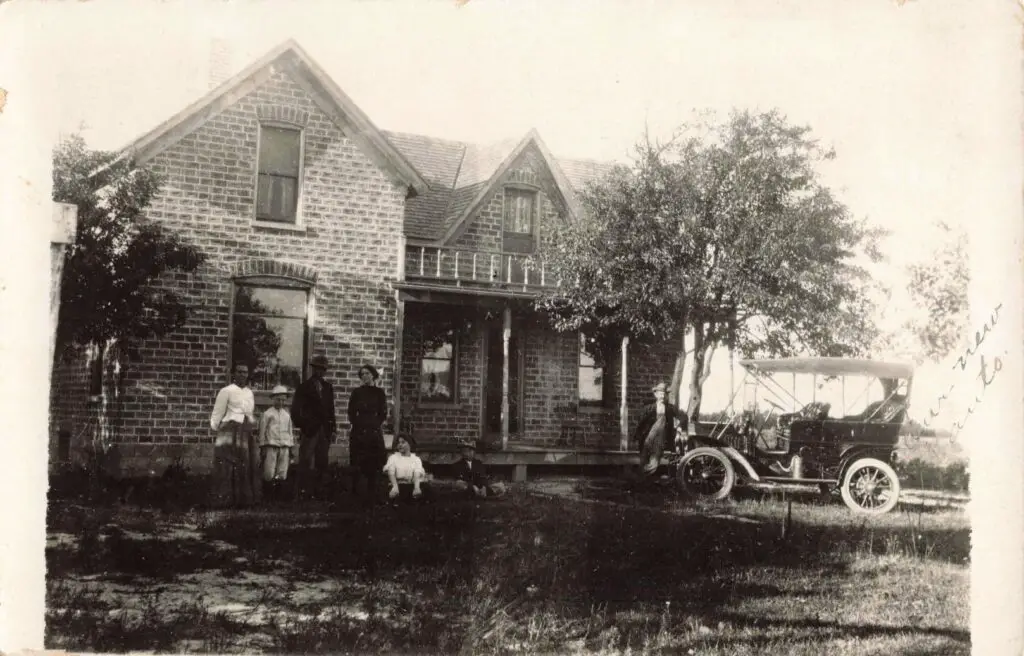 a group of people standing in front of a brick house