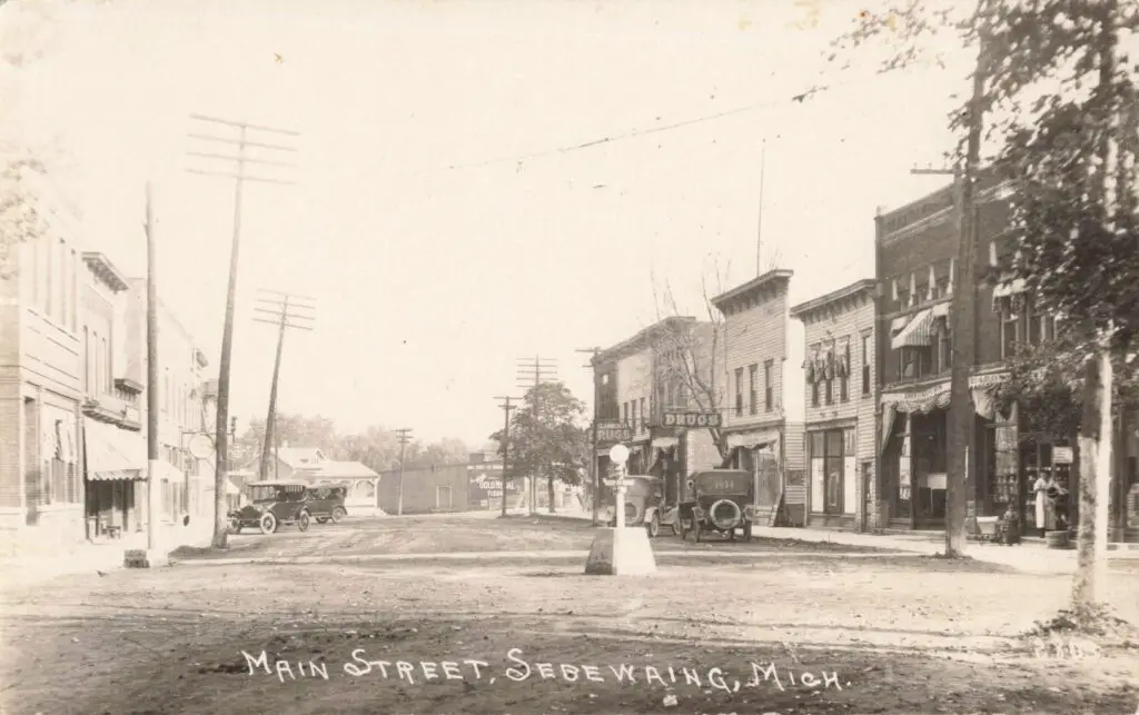 a black and white photo of a street with cars and buildings