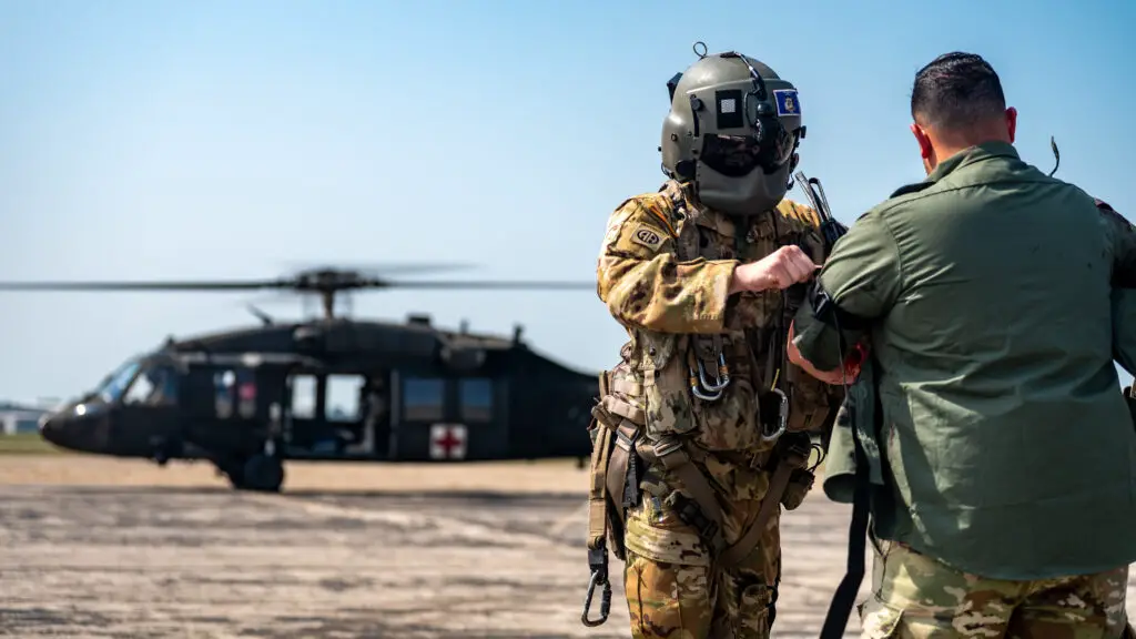 a man in military uniform with a helicopter in the background