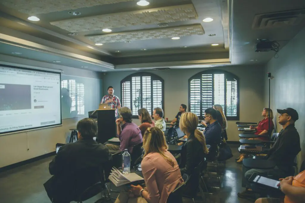a man standing in front of a group of people in a room
