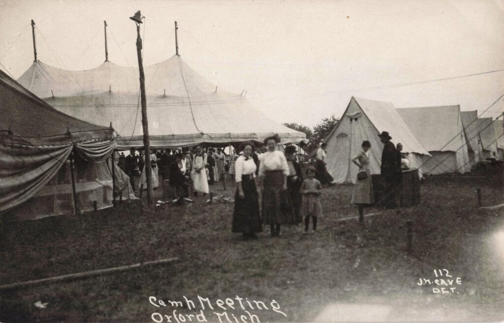 Historic gathering with tents and people.