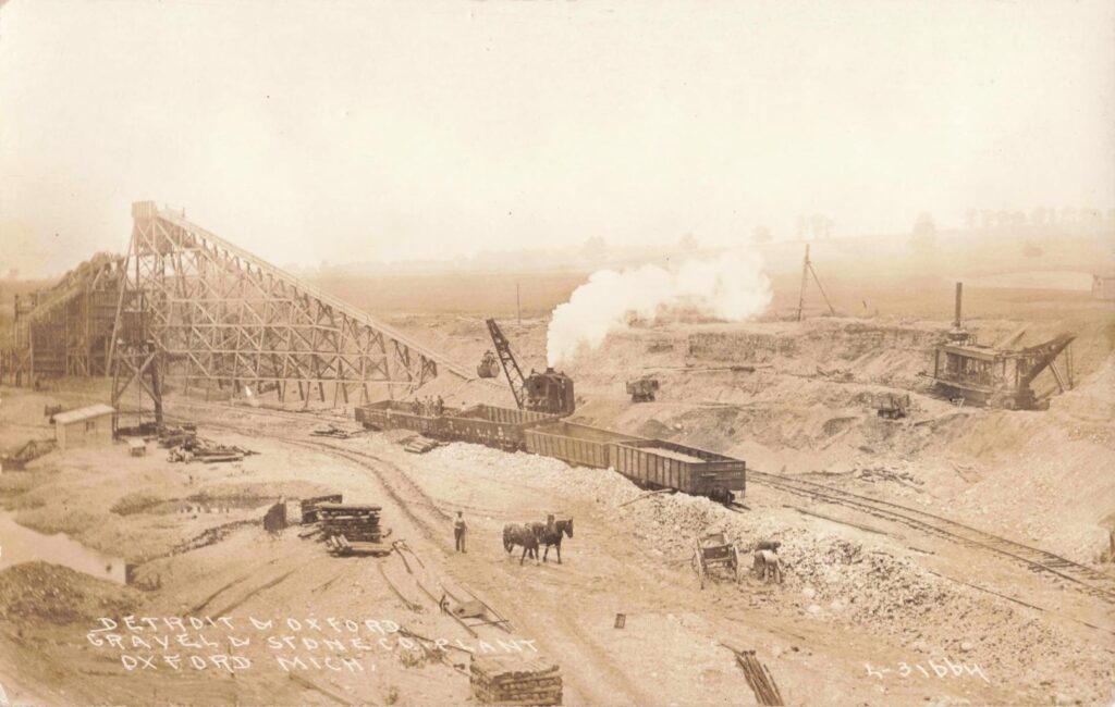 Historic mining site with machinery and horses.
