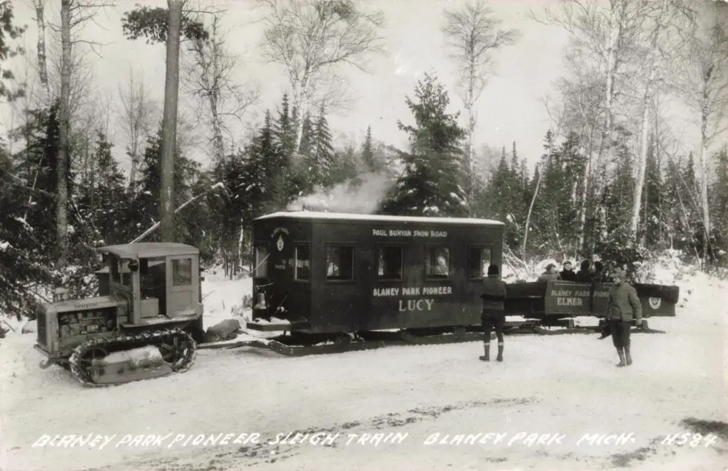 Historic snow train in forest setting.