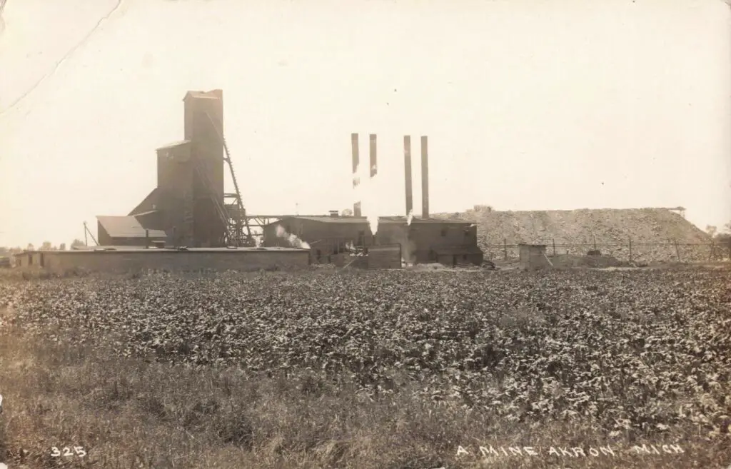 Old mine with smokestacks and fields.