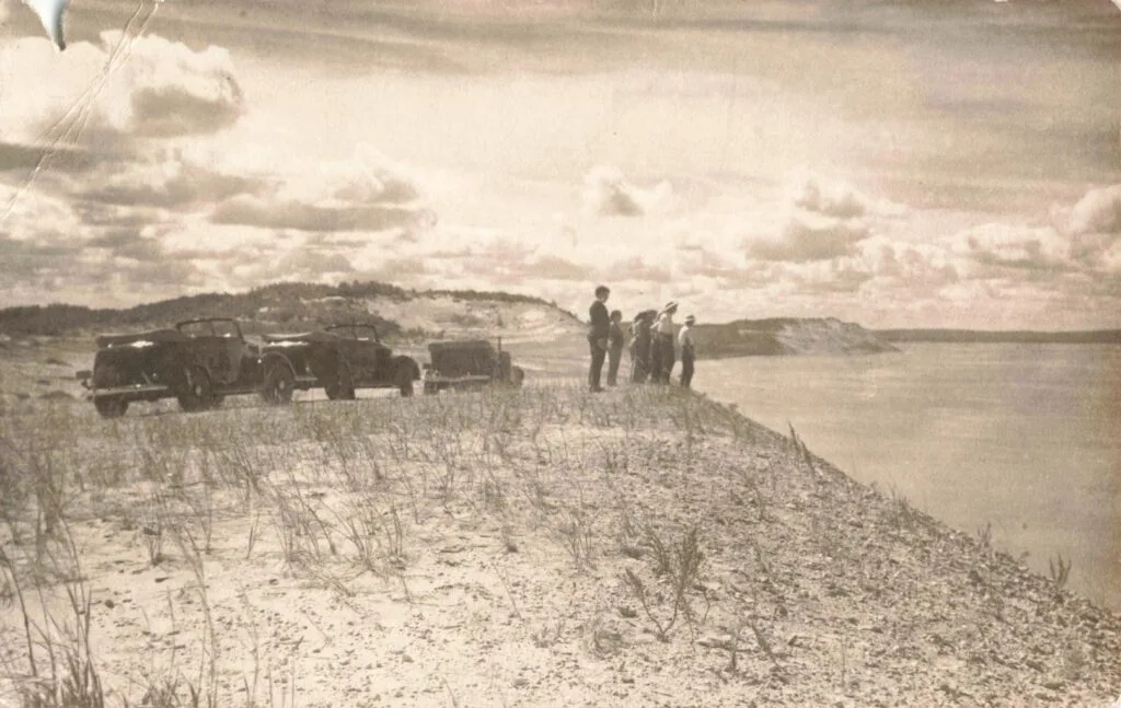 Vintage cars near sandy shoreline