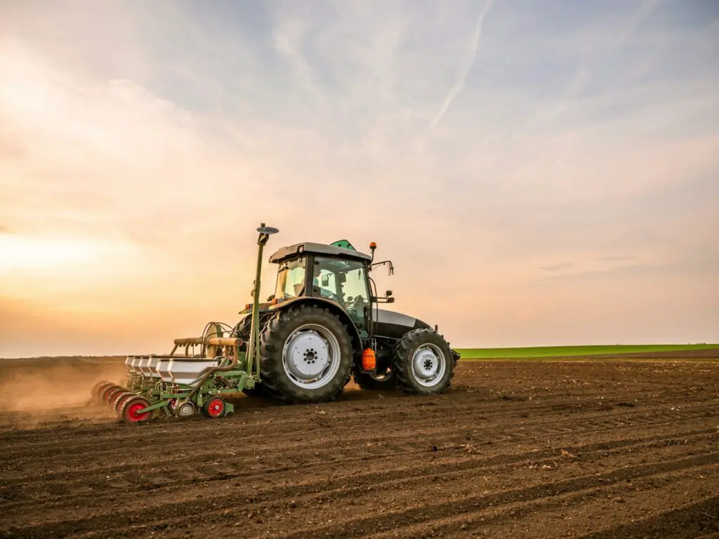 Tractor plowing field at sunset. - Michigan tractor theft ring