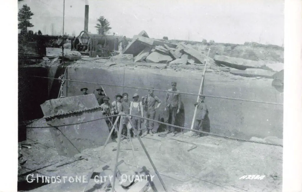 Historic quarry with workers and machinery.
