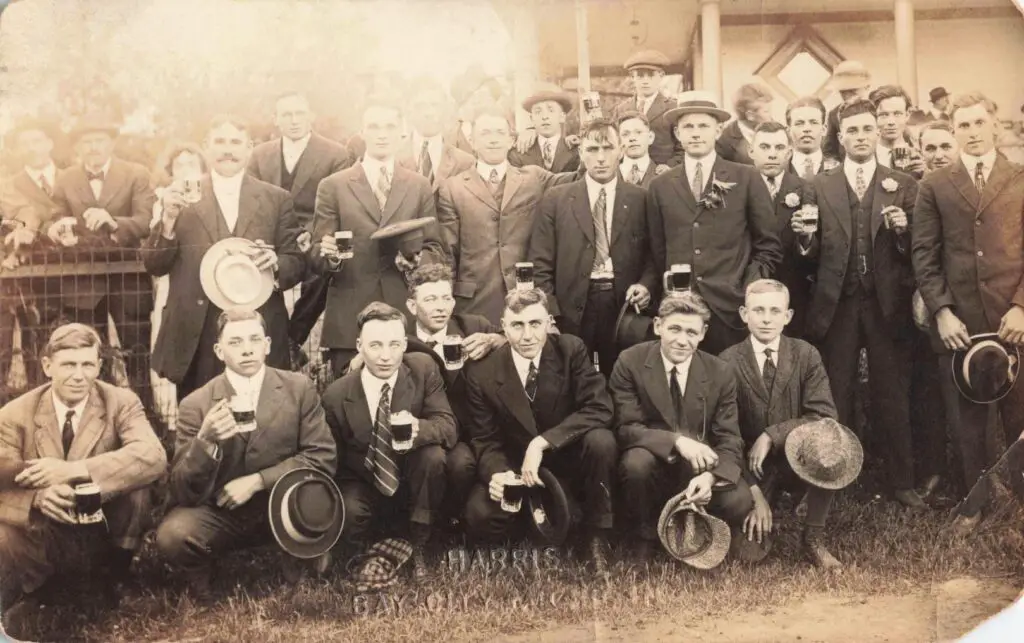 Group of men holding drinks outdoors.