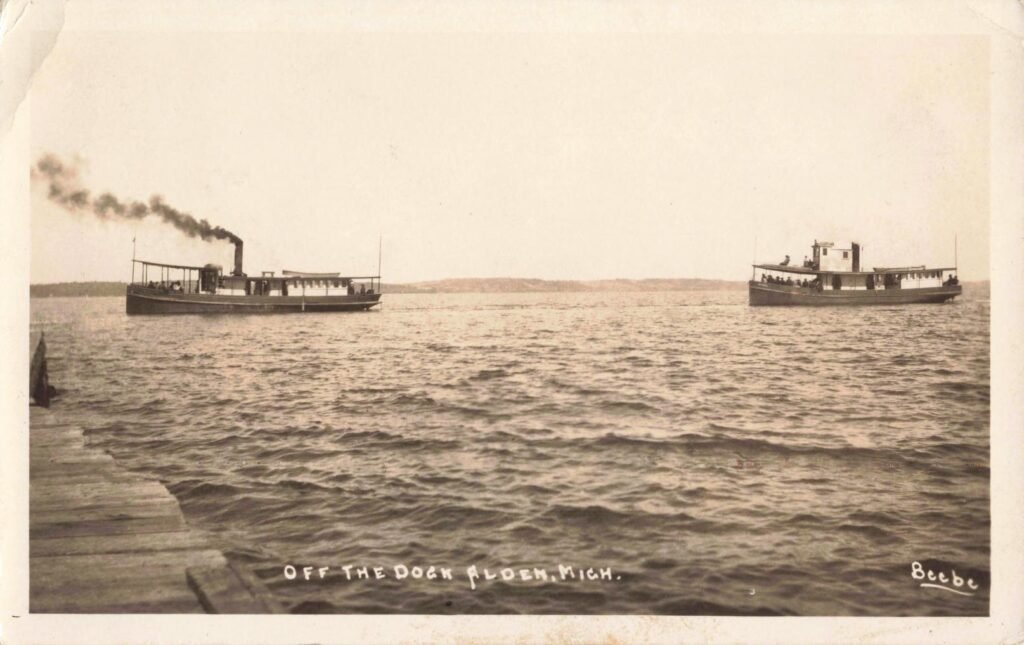 Two steamers on a calm lake.